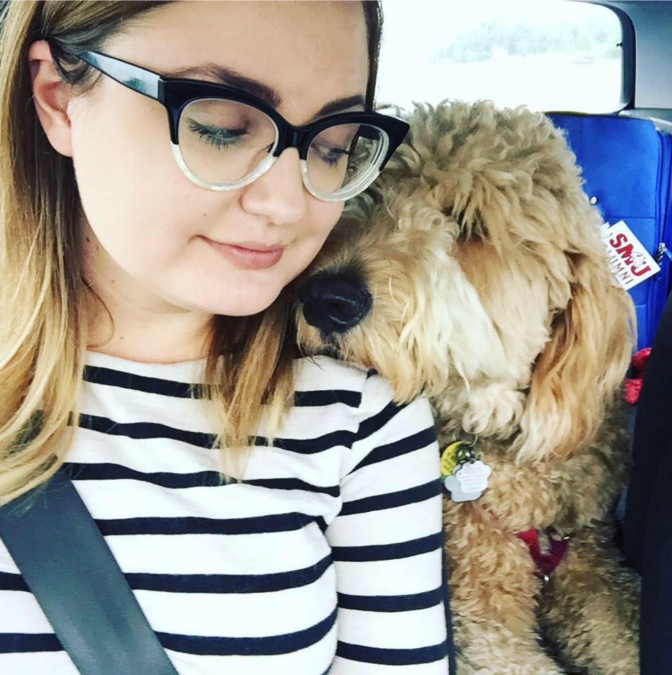 Photo of Sarah MacDonald, sitting in a car with her dog