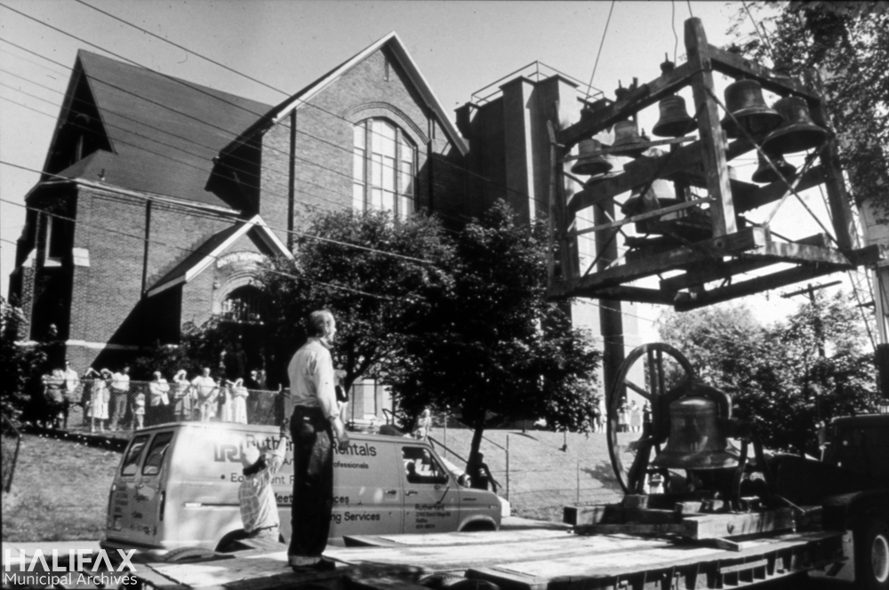 Black and white photograph of church bell carillon being loaded onto a flatbed truck