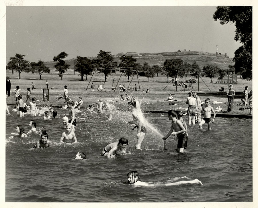 Black and white photo of children swimming with Citadel and Common in background