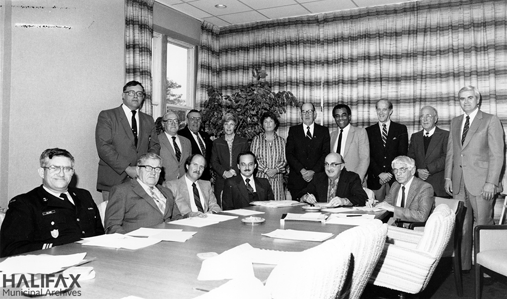Black and white group portrait of committee in board room
