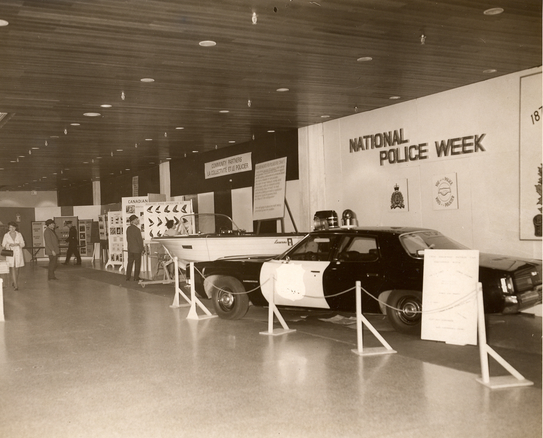 Black and white photo of a cruiser on display under a National Police Week banner