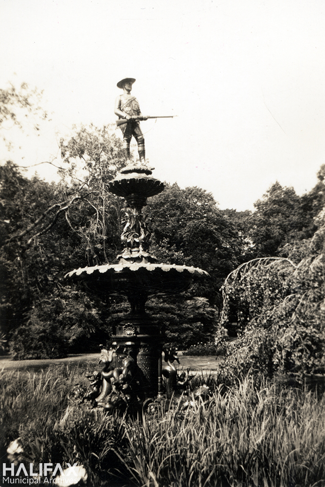 Black and white image of a fountain with a soldier holding a rifle on top, commemorating the Boer War
