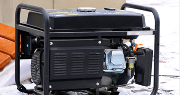 Image of a generator outside on the snow covered ground.