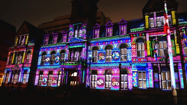 A colourful photo of grand parade and City Hall all lit up for Christmas