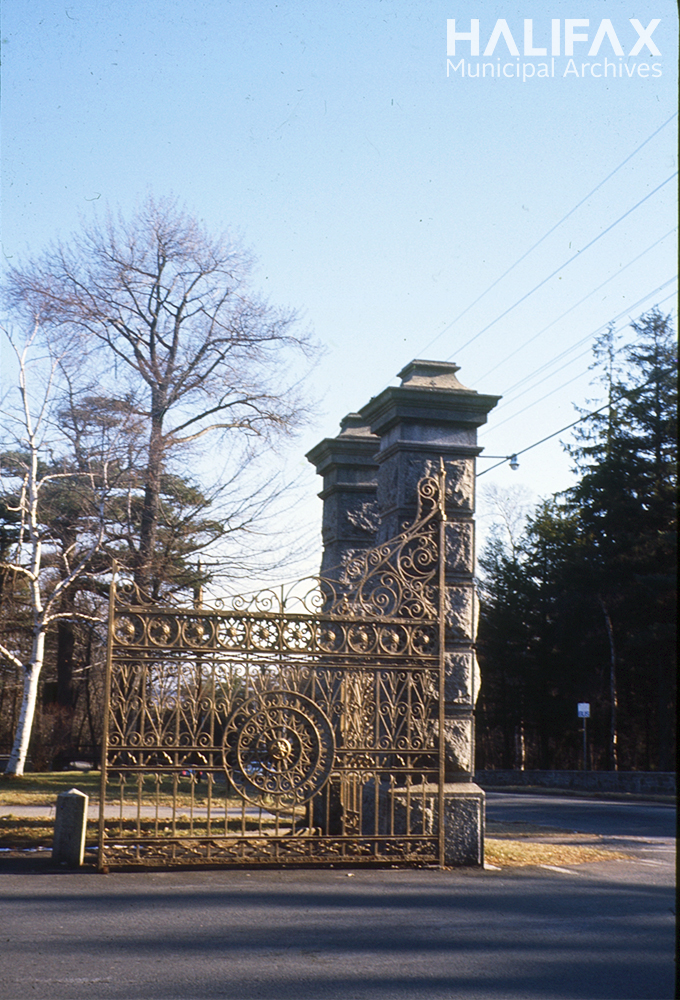 Colour photo of golden metal gates and stone pillars