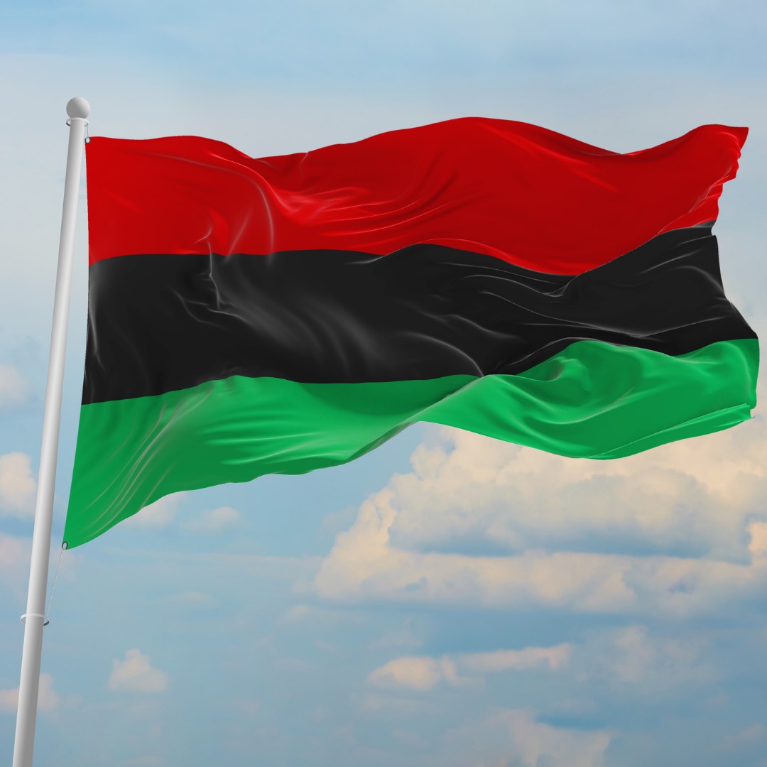 the Pan-African flag blowing in the wind on a flag pole