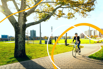 A cyclist riding through the Halifax Common on a sunny day