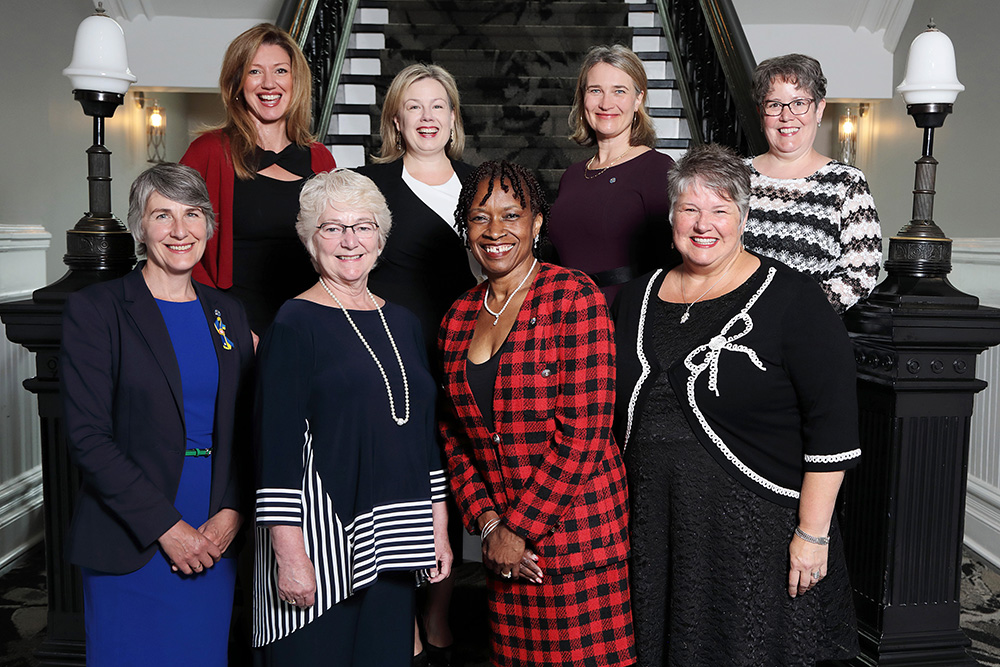 Colour photograph of female councillors standing on the interior stairs of Halifax City Hall.