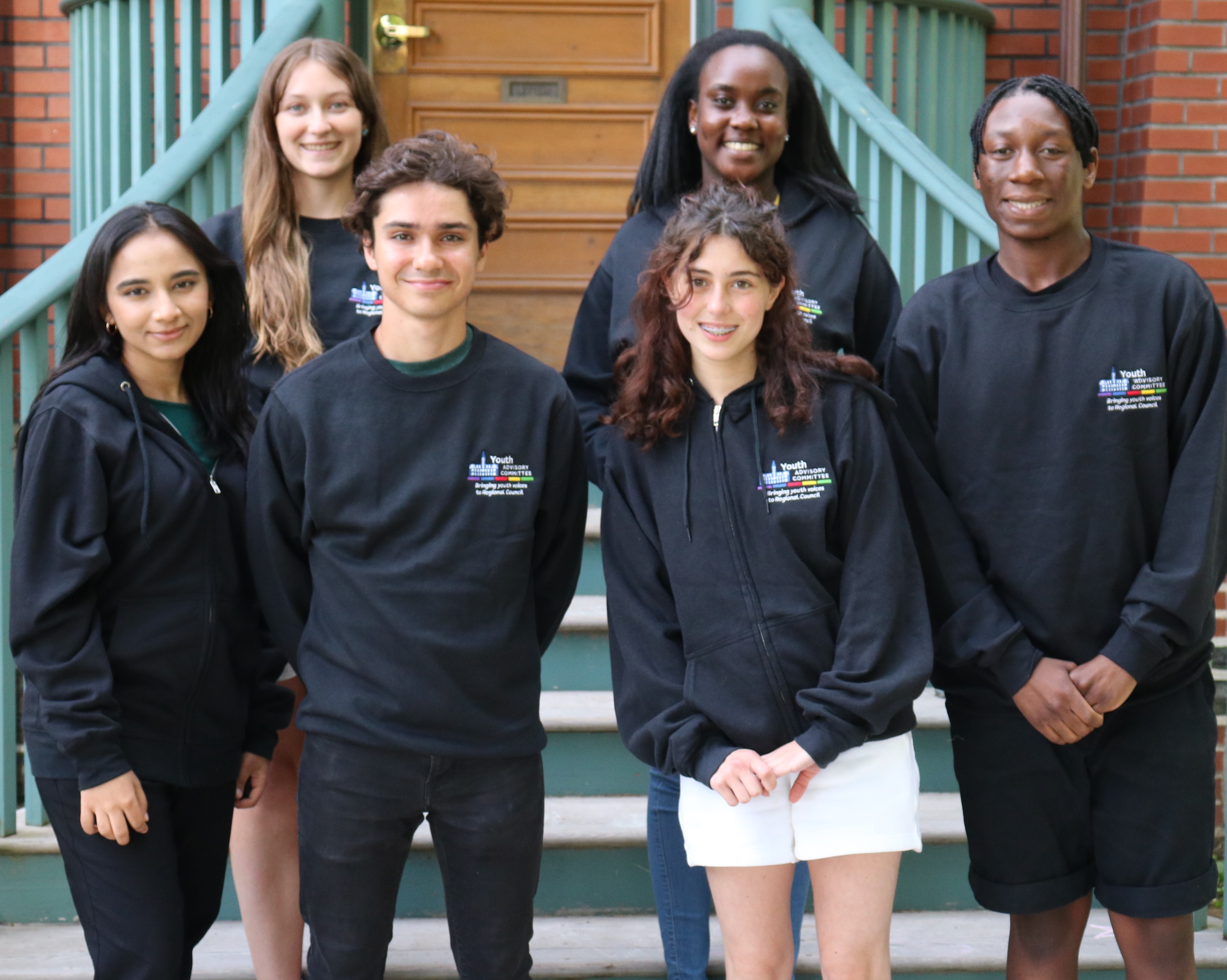 A group of youth standing in front of stair