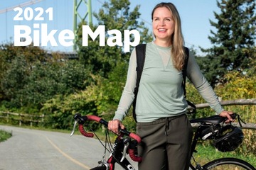 A woman holds her bike and helmet on the Barrington Greenway. The MacDonald Bridge is visible in the background. Text reads "2021 Bike Map"