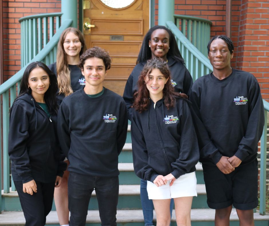 Members of the youth advisory committee stand together on the front steps of the Powerhouse Youth Centre