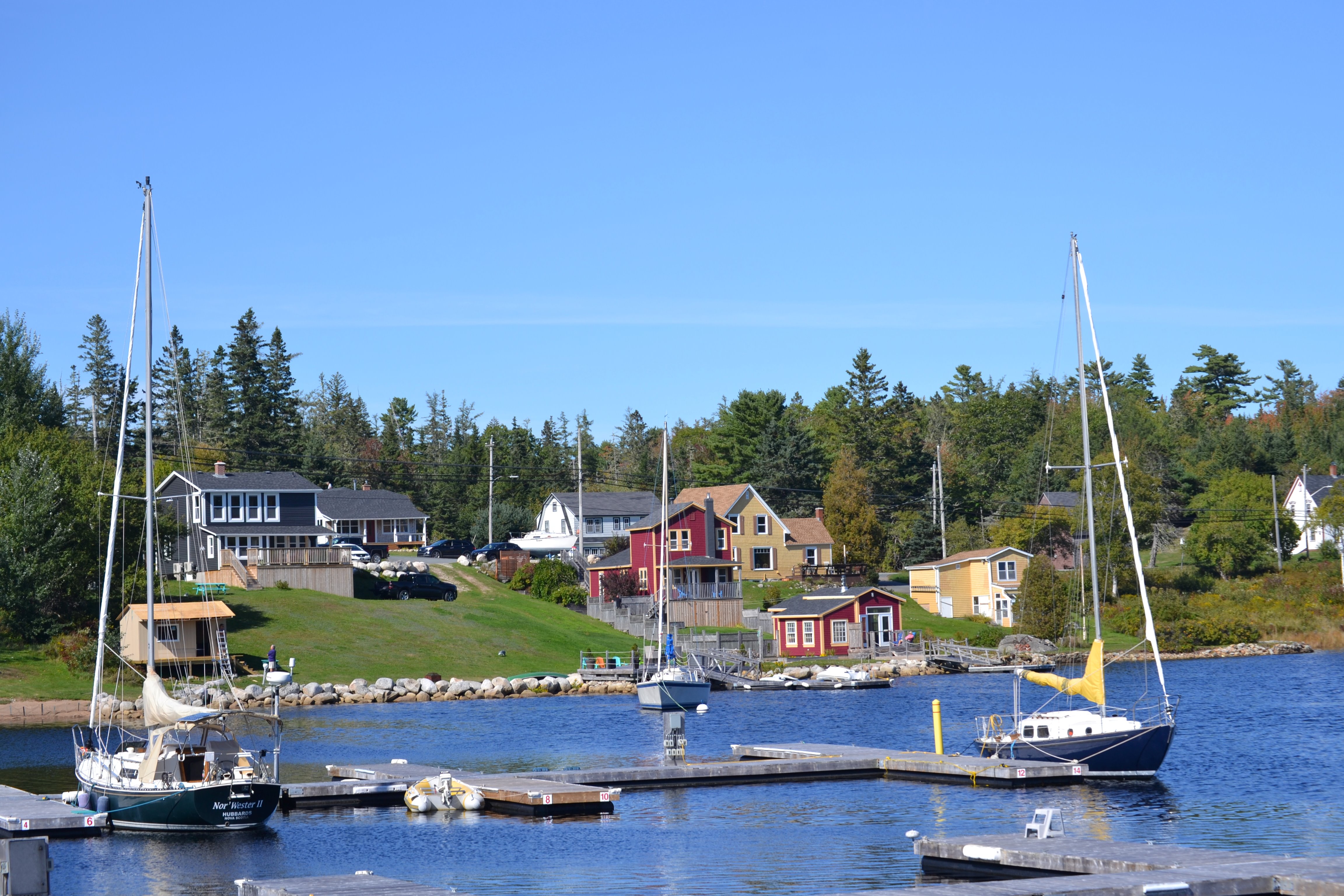 Sailboats are floating in a bay on a sunny day.