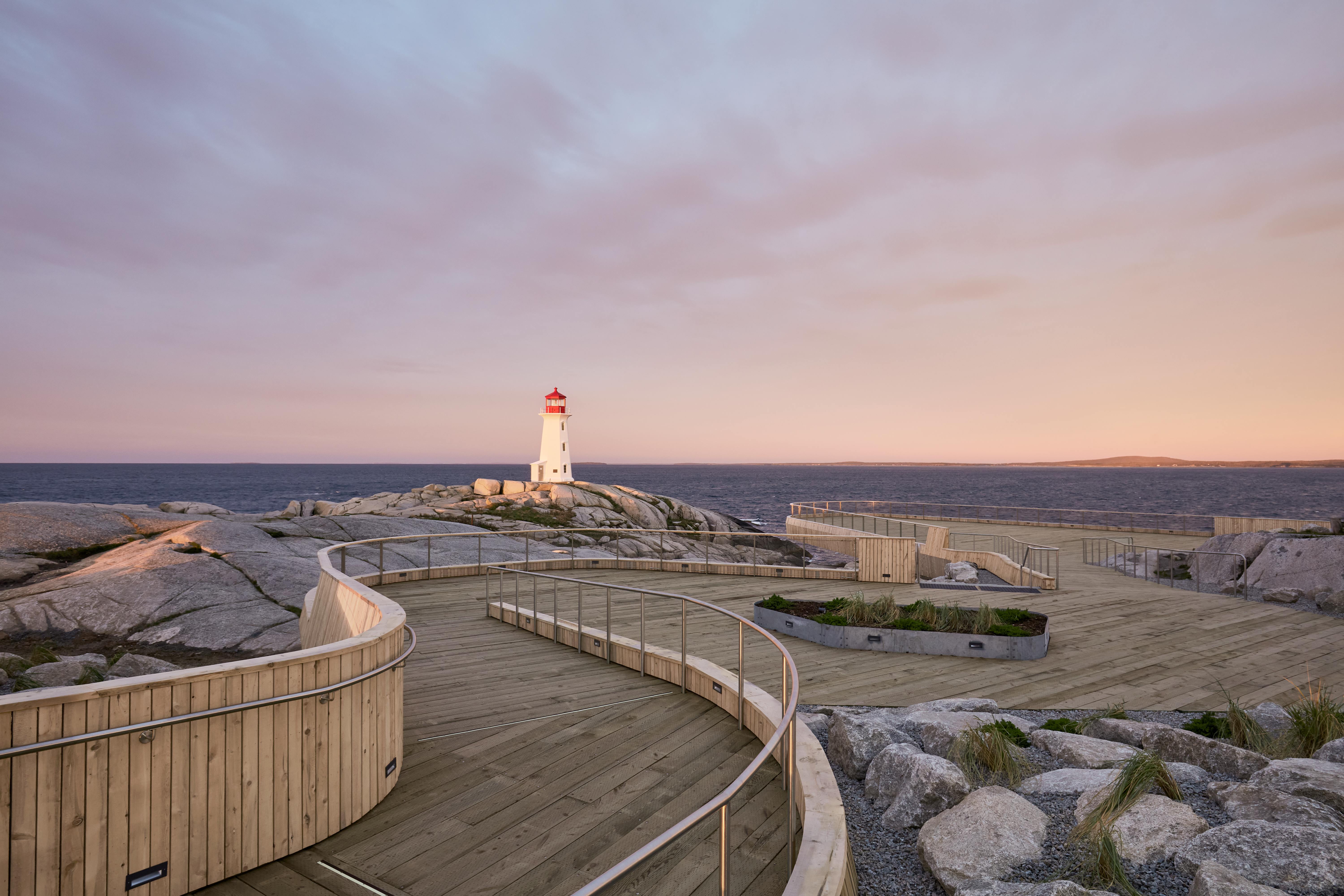 A shot of Peggy's Cove Viewing Deck with a sunset and lighthouse in the background.