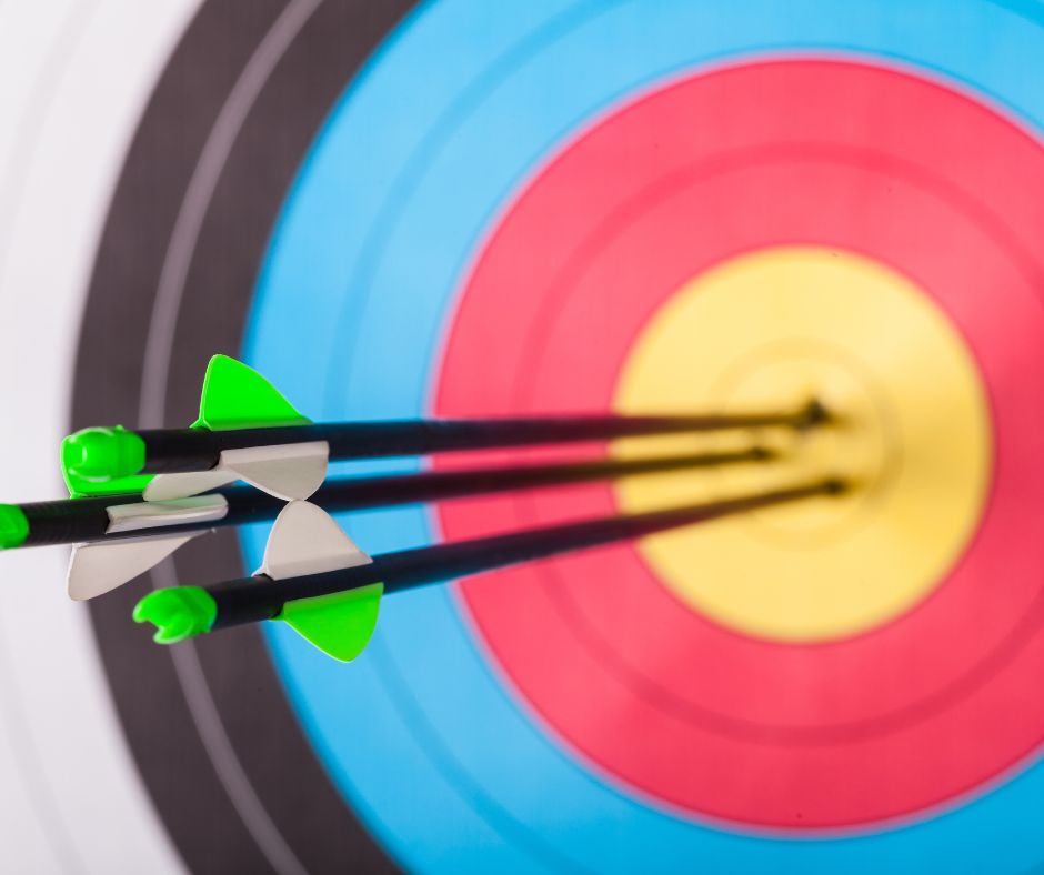 An archery target with arrows sticking out of the bullseye 