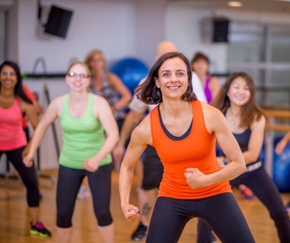 a fitness class with a group of women wearing colourful clothing