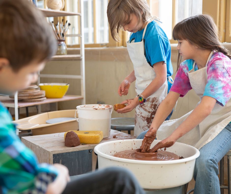 three kids doing pottery