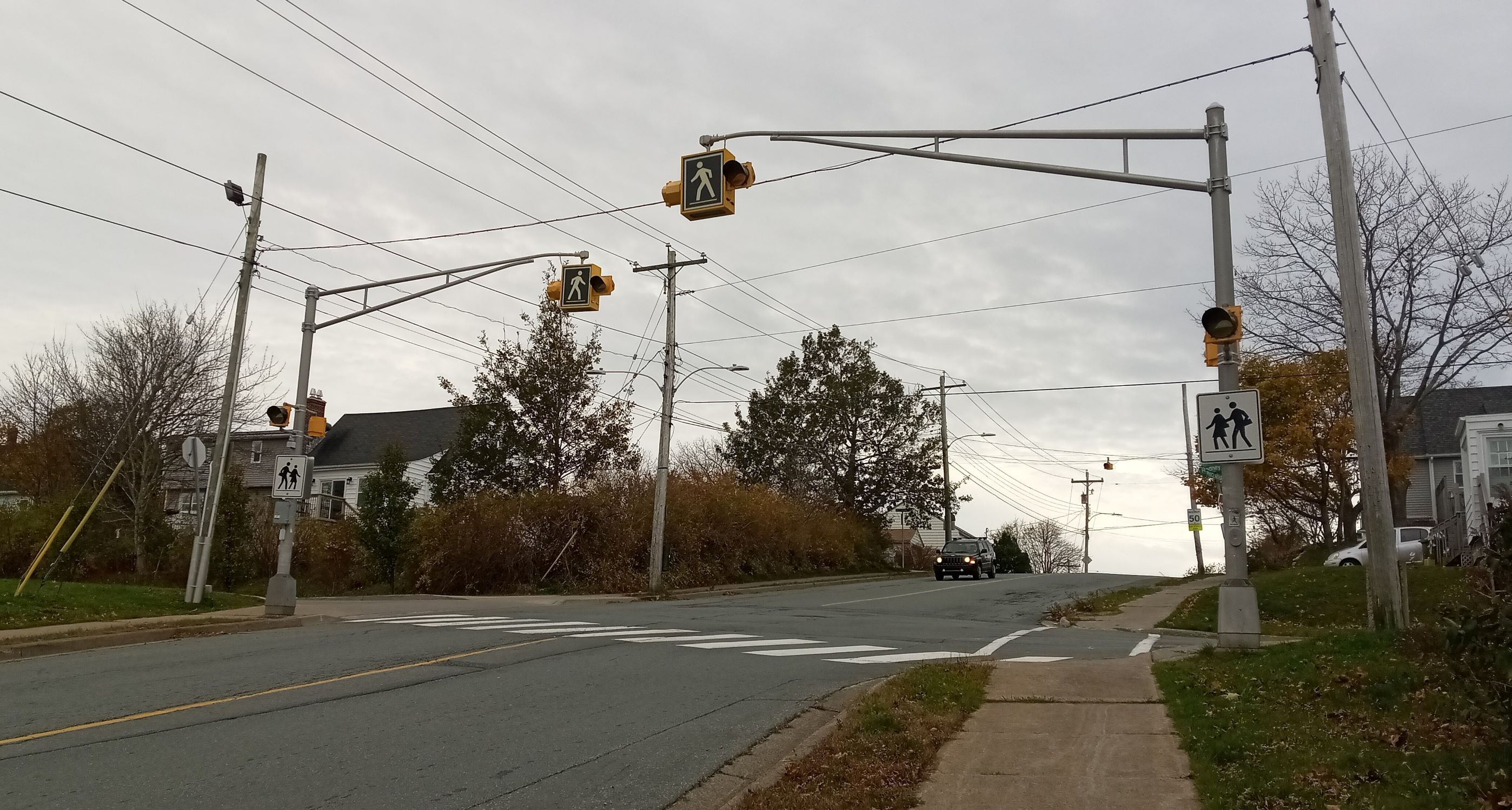 Road with a crosswalk that has overhead flashing beacons