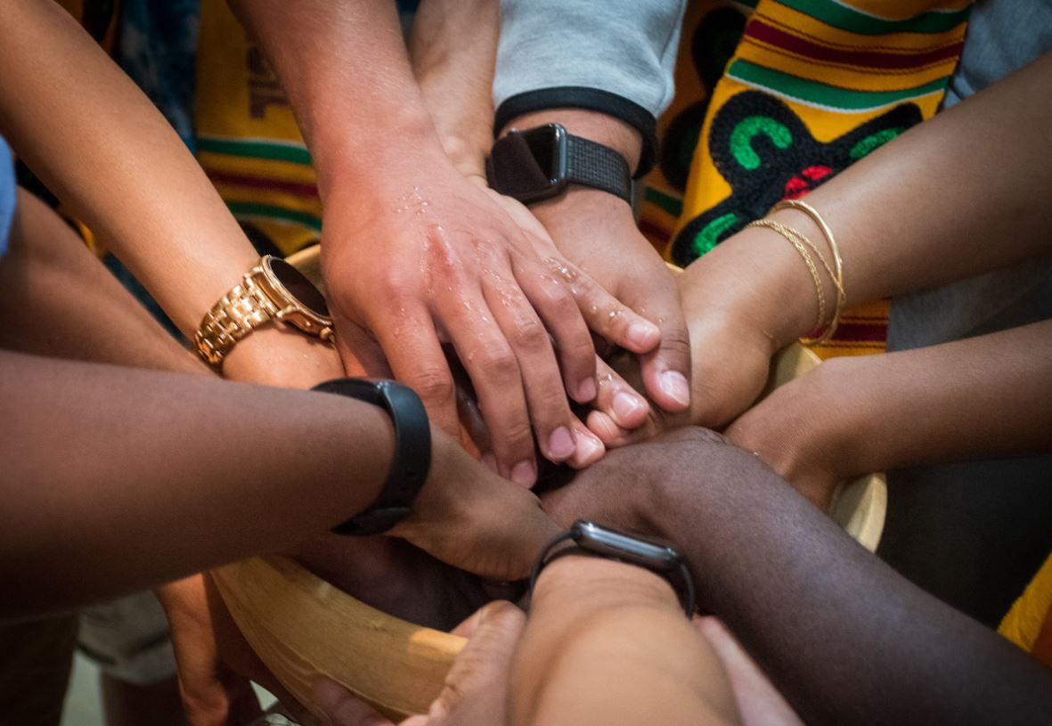 many hands in wood dish 