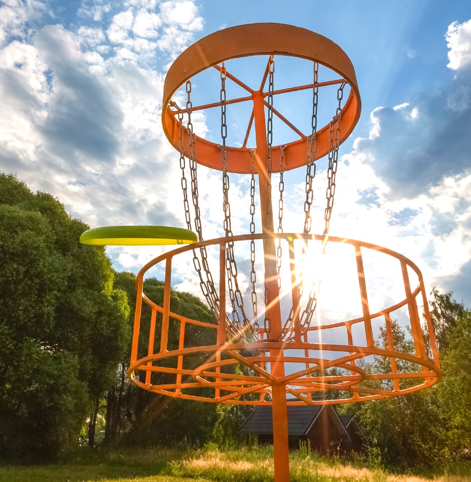 An orange disc golf rack with a blue sky background