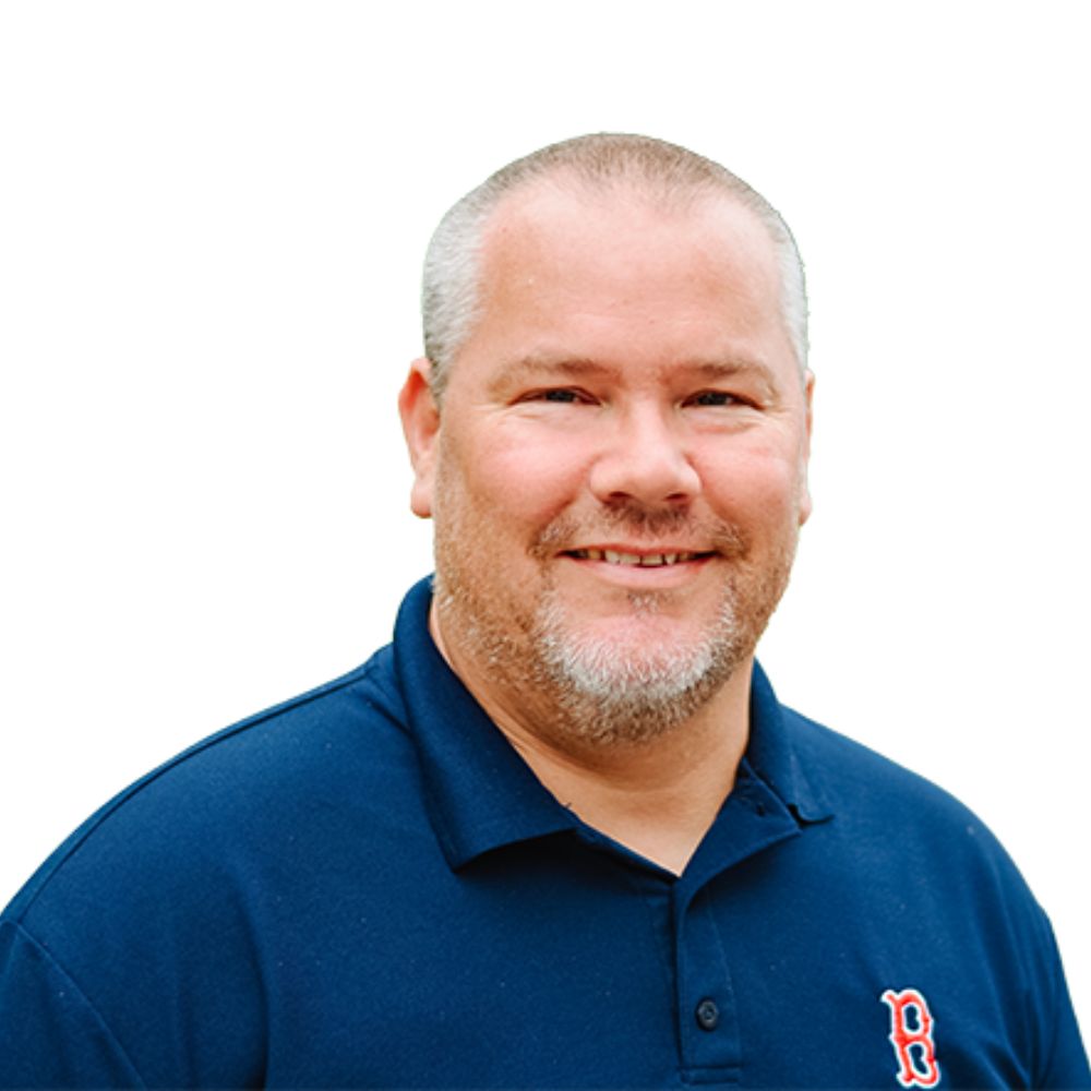 Man wearing a polo shirt smiling at the camera.