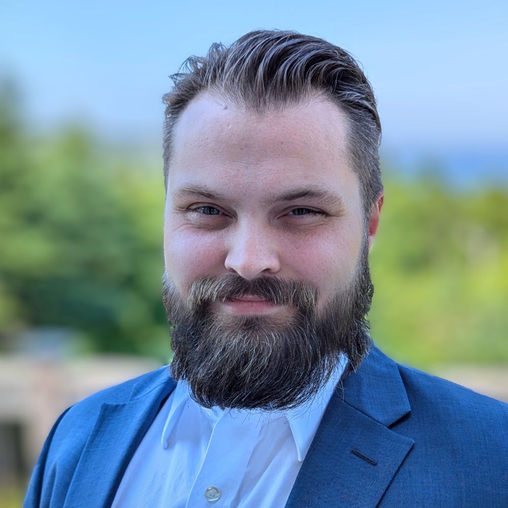 Man standing outside smiling at the camera.