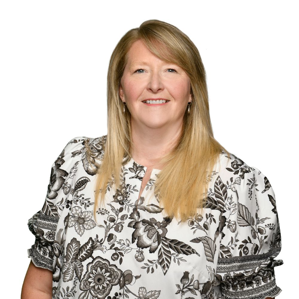 Woman with floral shirt smiling at camera.