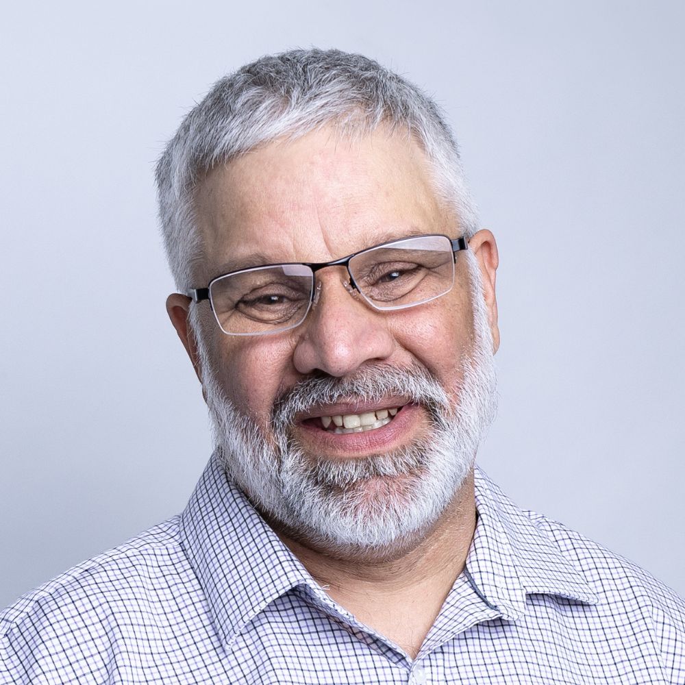 Man with glasses smiling at the camera.