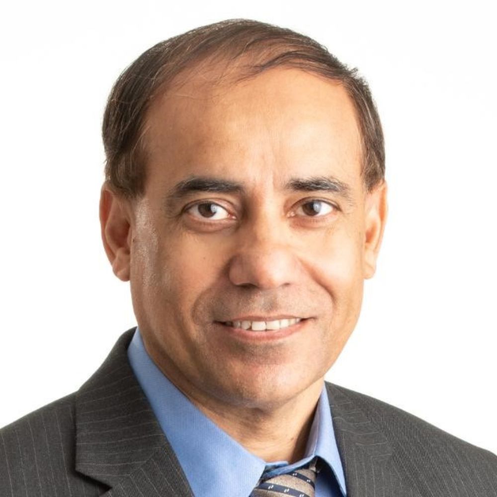 Man in suit and tie smiling at camera.