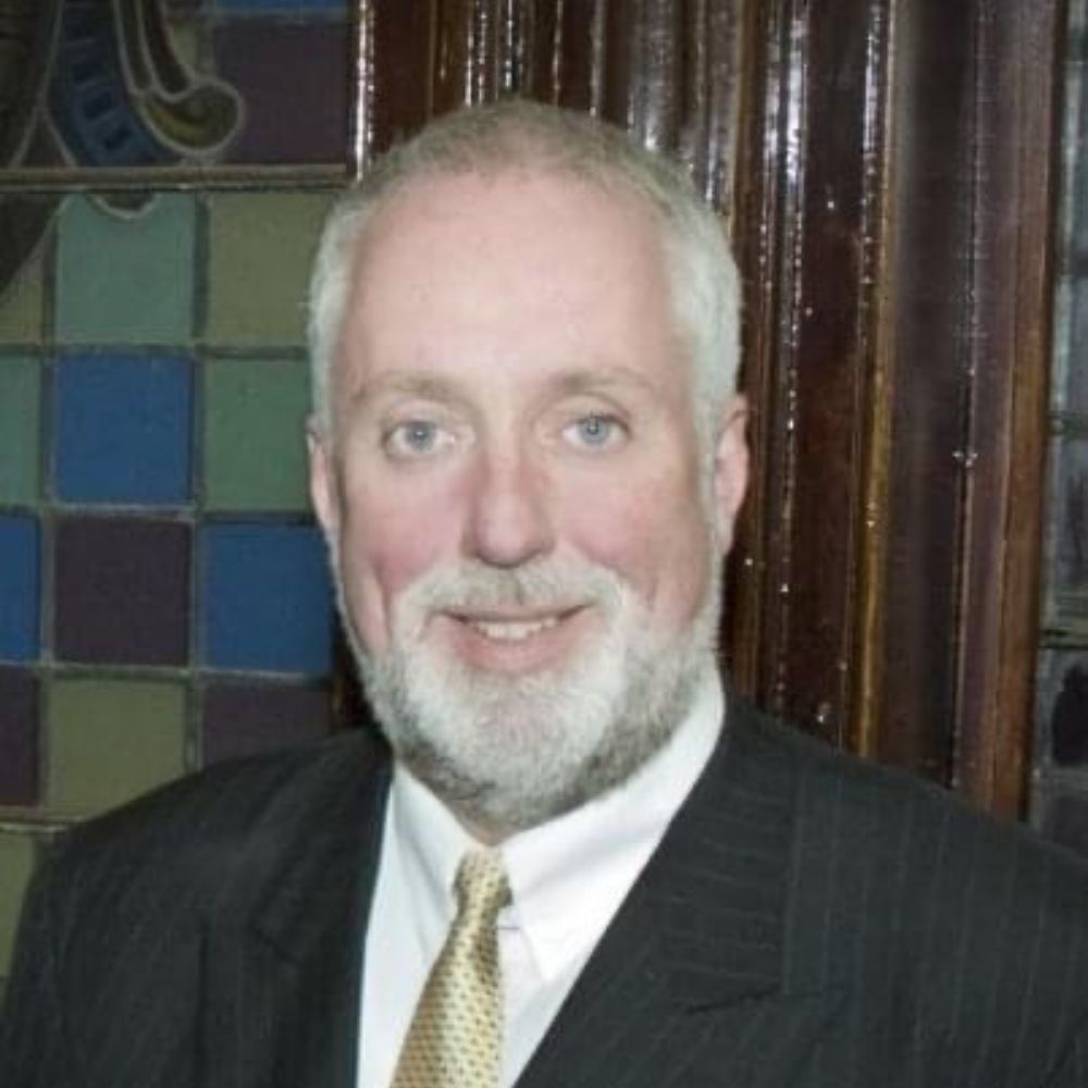 Man in suit and tie smiling at camera.