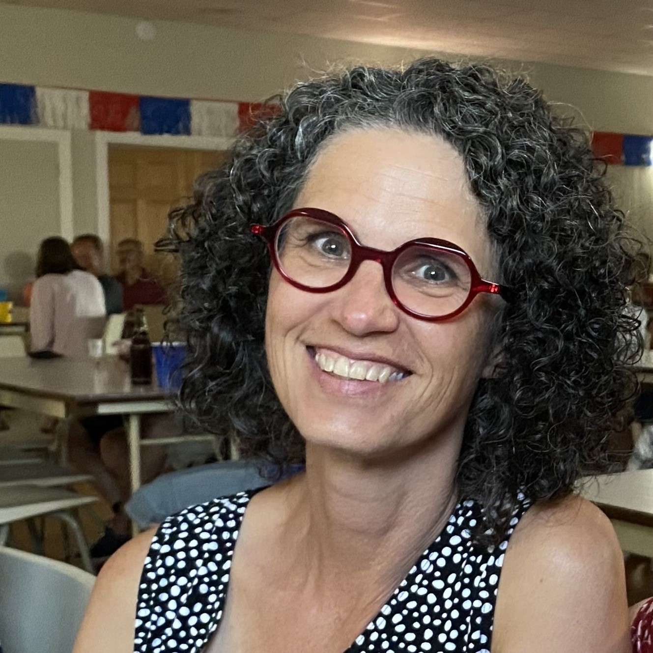 Woman wearing glasses smiling at the camera.