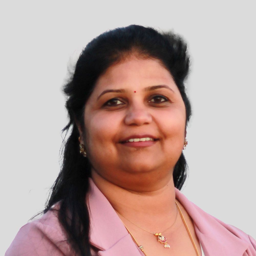 Woman wearing a blazer and smiling at the camera.