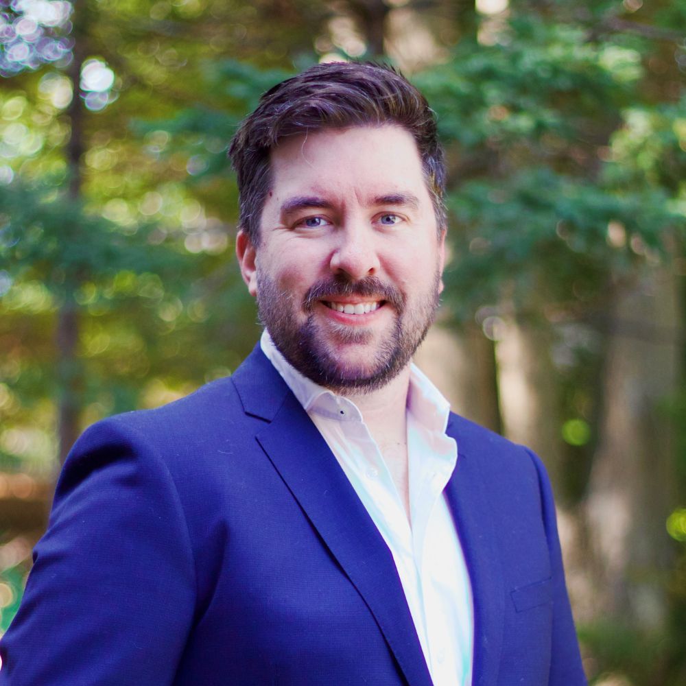 Man wearing suit smiling at the camera.