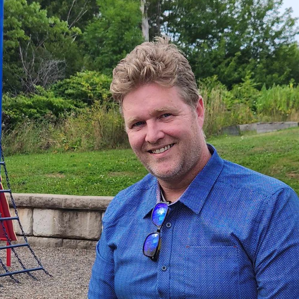 Man standing outside smiling at the camera.