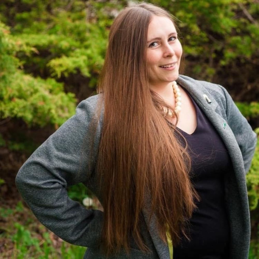 Woman standing outside smiling.