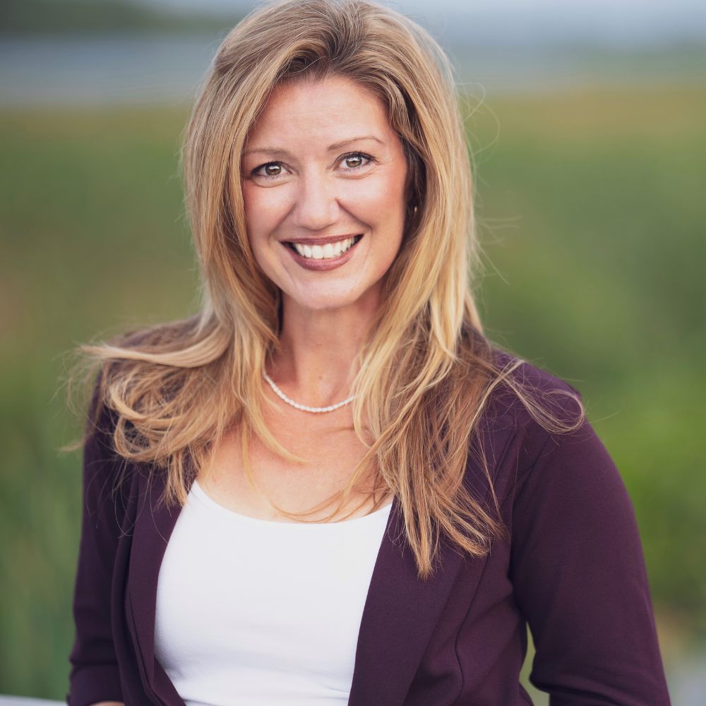 Woman standing outside smiling at the camera.