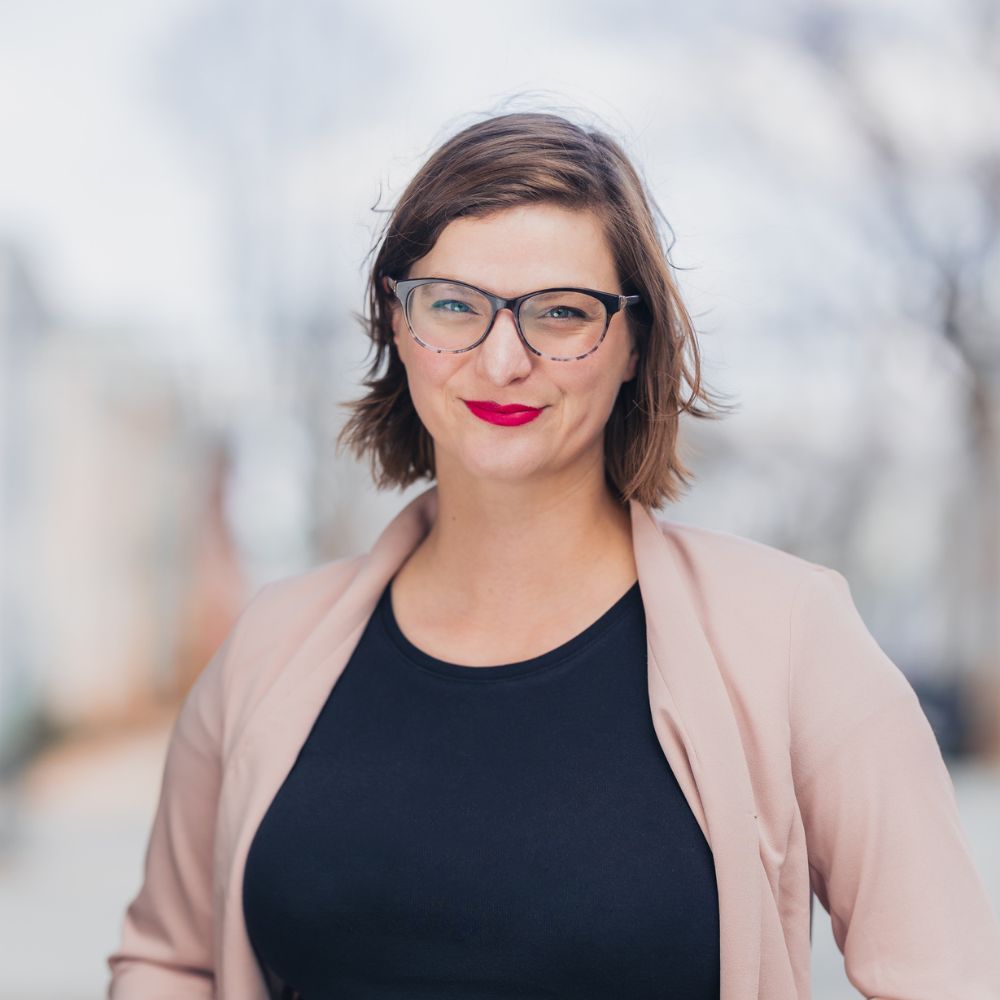 Woman standing outside smiling at camera.