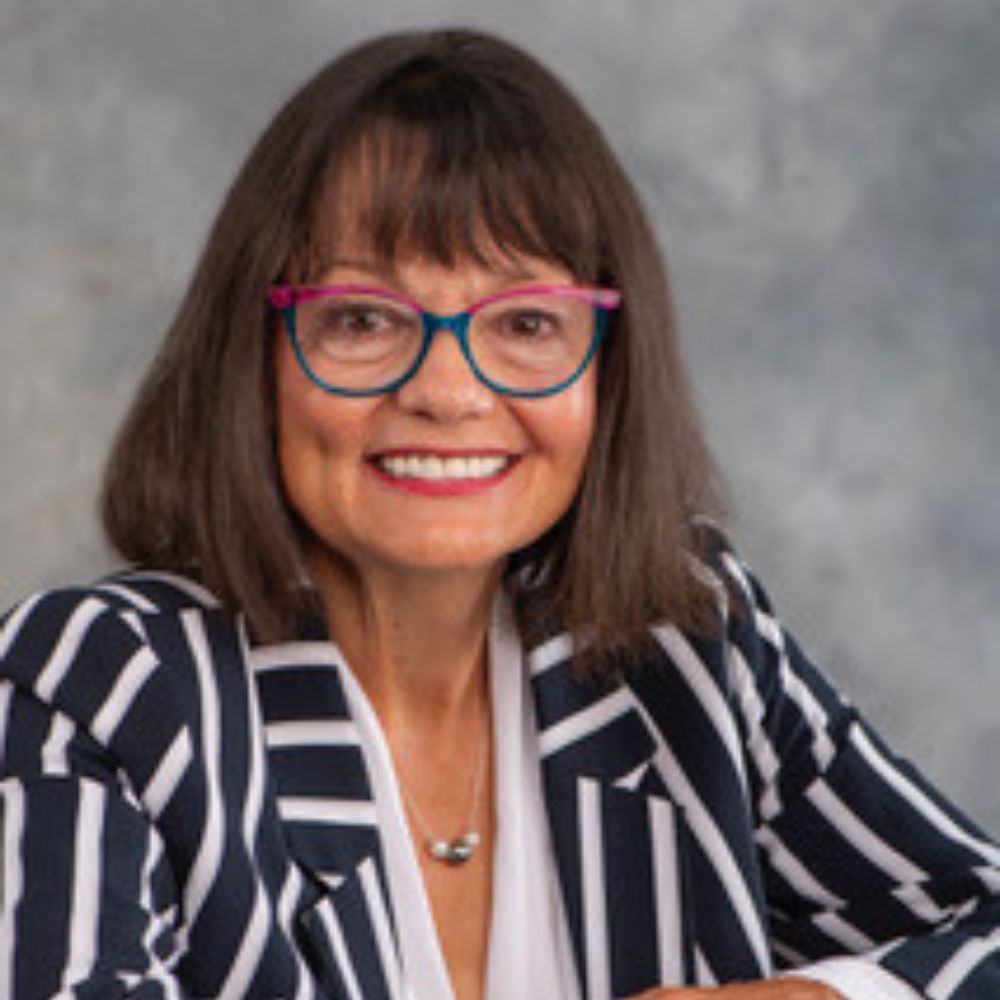 Woman wearing glasses smiling at camera.