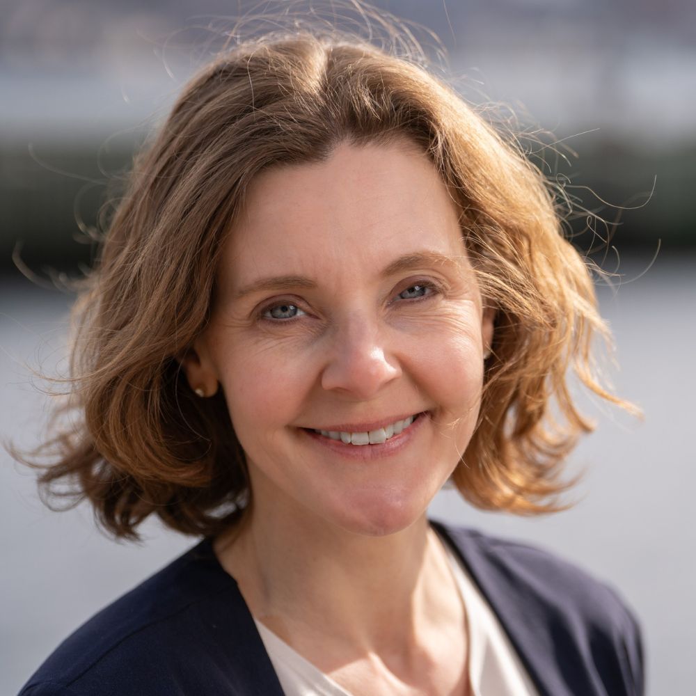 Woman standing outside smiling at camera.