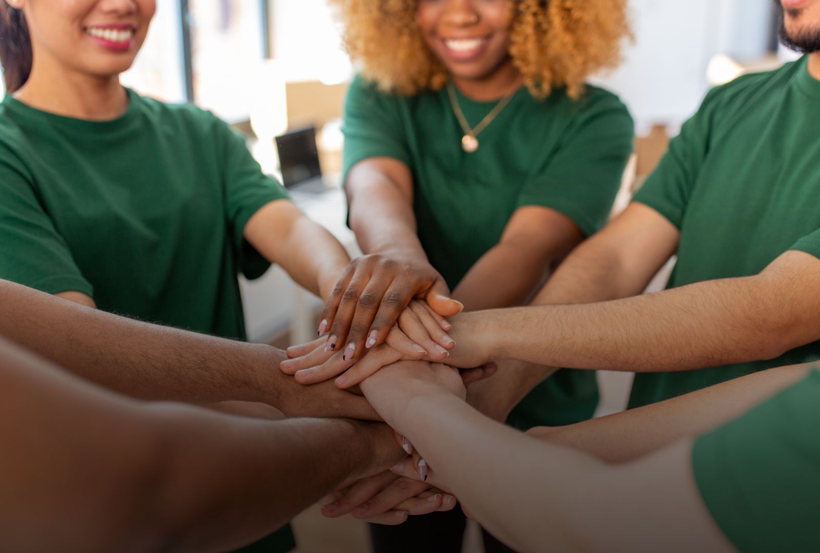 Photo of a diverse team of volunteers doing a team hand stack