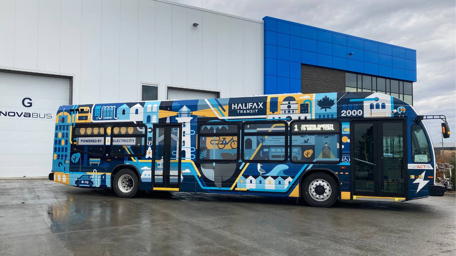 Halifax Transit electric bus against the backdrop of a blue and white building