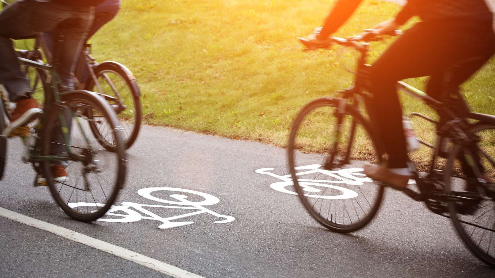 Two bikes travelling on a bike lane. 