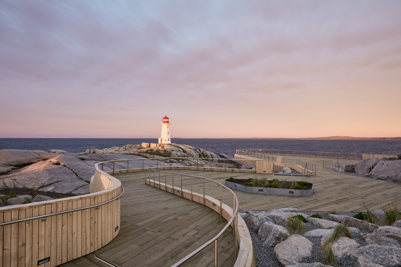 Image of the Peggy's Cove lighthouse viewing deck at sunset.