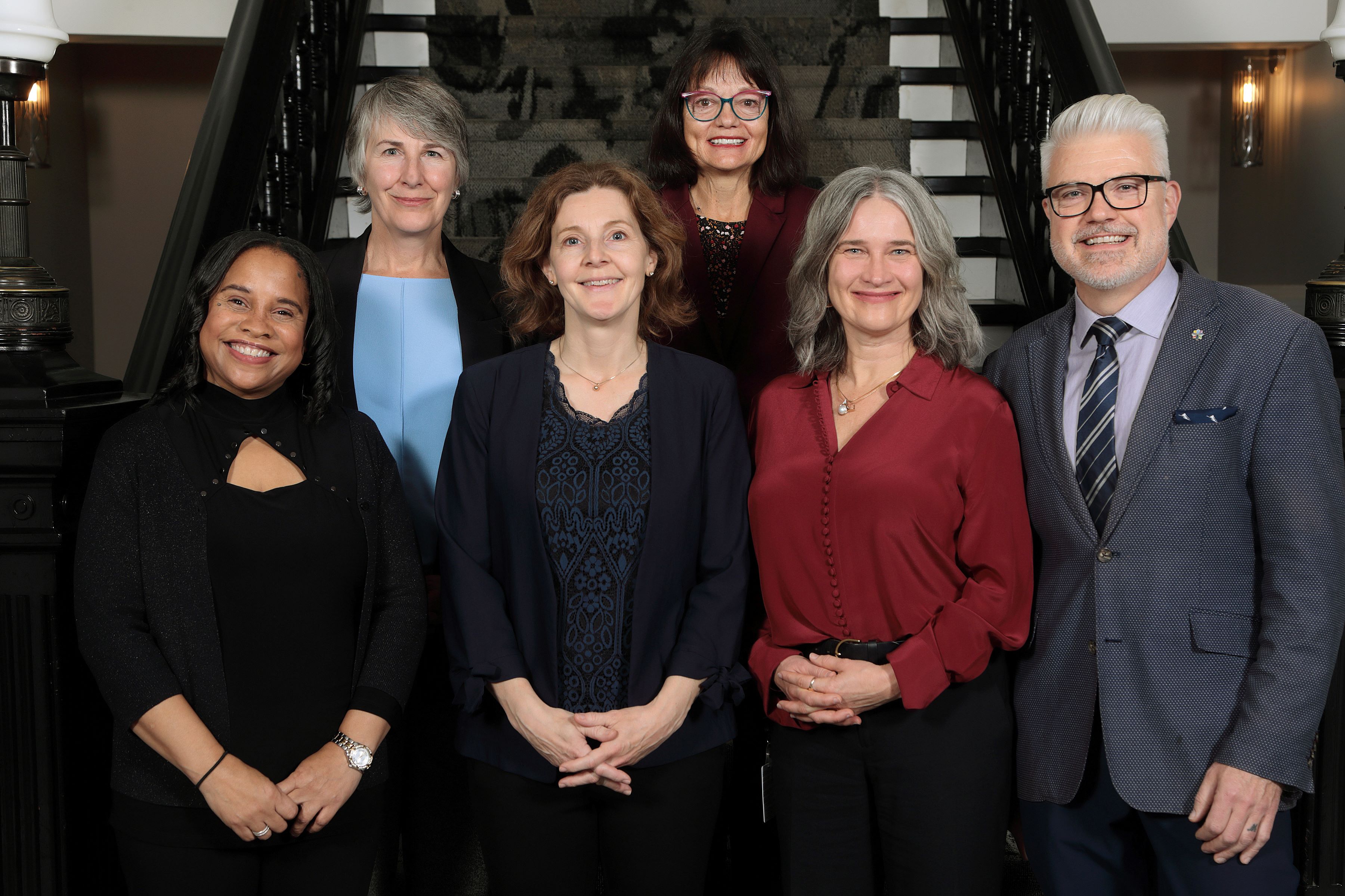 Members of Halifax and West Community Council stand together in front of the stairs inside City Hall