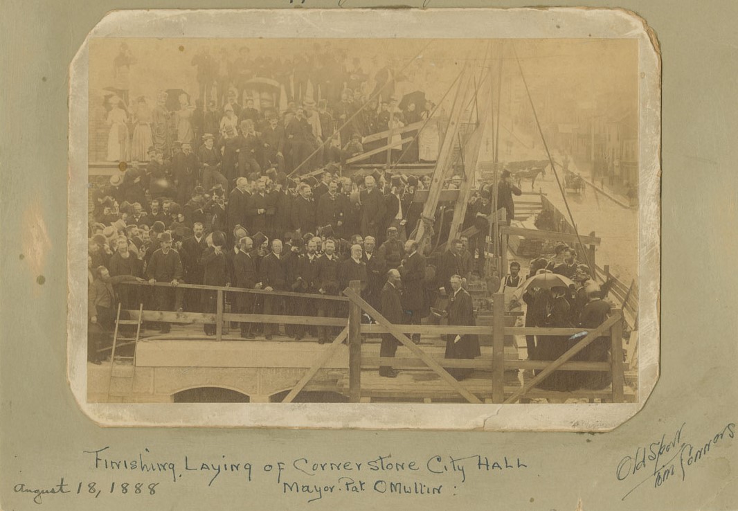 Sepia-toned photograph of many people gathered on scaffolding above Barrington and Duke Streets with elegantly-dressed men and women in the lower-right corner involved in a ceremony.