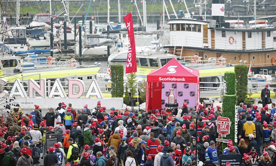 A large crowd wearing red toques gathers at the Halifax waterfront for Scotiabank Hockey Day in Canada.