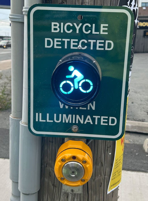 Photo of a bicycle indicator light & sign at the intersection of Almon and Robie streets. The illuminated light provides feedback to cyclists that they have been detected.