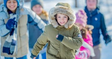 children wearing winter coats running outdoors