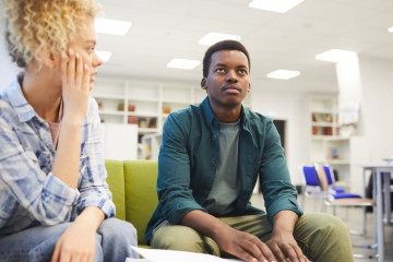 Two people sitting next to each other