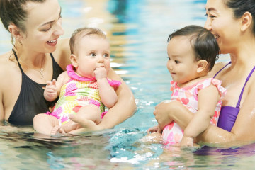 two ladies with babies in the pool