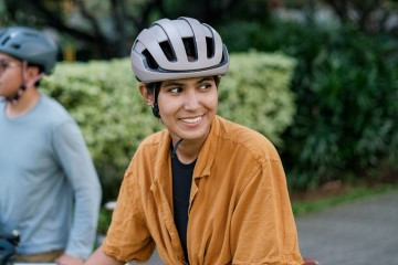 Two people riding their bicycles with helmets on